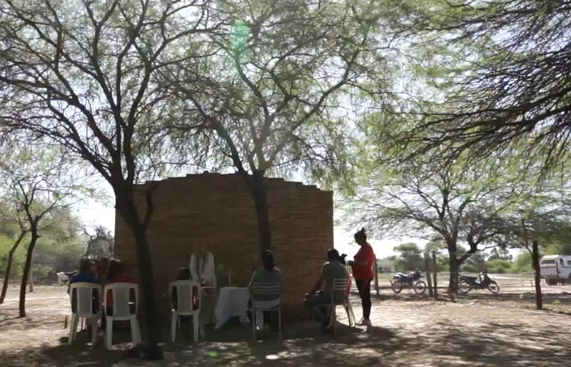 Under a tree, mud building